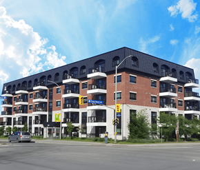 Ottawa apartment for rent - A large red brick building with a black roof and balconies.