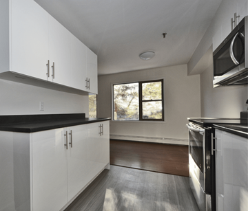 Halifax apartment for rent - A modern kitchen with white cabinets and black countertops.