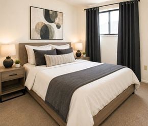 London apartment for rent - A bedroom with a large bed, a nightstand with a lamp, and a painting on the wall.