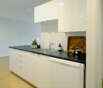 Bedford apartment for rent - A modern kitchen with white cabinets and a black countertop.