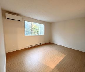 Fredericton apartment for rent - A room with a window and a wall-mounted air conditioner.