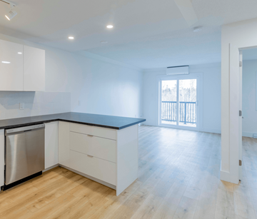 Fredericton apartment for rent - A kitchen with white cabinets and a black countertop.