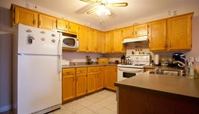 Stratford apartment for rent - A kitchen with wooden cabinets and a white refrigerator.