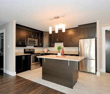 Bedford apartment for rent - A modern kitchen with dark wood cabinets and stainless steel appliances.