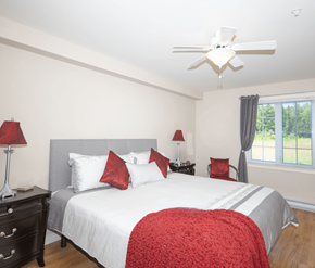 Fredericton apartment for rent - A bedroom with a large bed and a ceiling fan.
