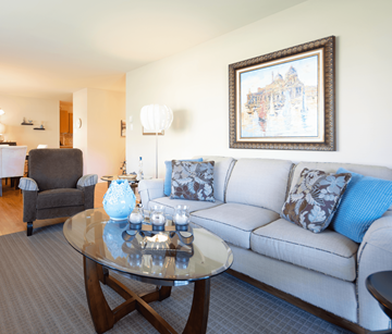 Fredericton apartment for rent - A living room with a couch, a coffee table, and a painting on the wall.