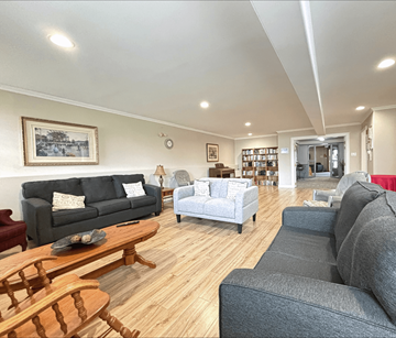 Dieppe apartment for rent - A living room with a grey couch, a wooden coffee table, and a painting on the wall.