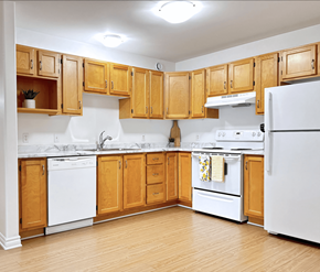 Dieppe apartment for rent - A kitchen with wooden cabinets and white appliances.