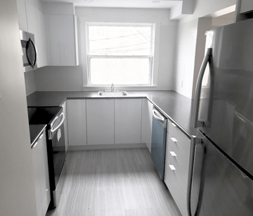 Halifax apartment for rent - A kitchen with white cabinets and a window.
