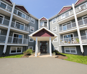 Dieppe apartment for rent - A large building with a red roof and white railings.