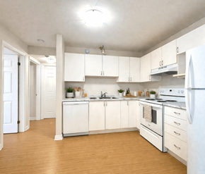 Dieppe apartment for rent - A kitchen with white appliances and wooden floors.