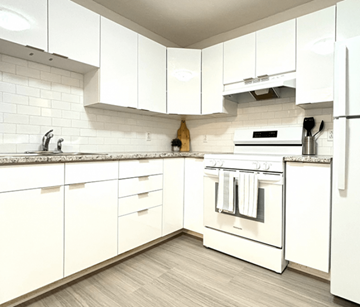 Dieppe apartment for rent - A white kitchen with a stove and a refrigerator.