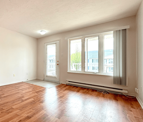 Dieppe apartment for rent - A room with wooden floors and white walls.