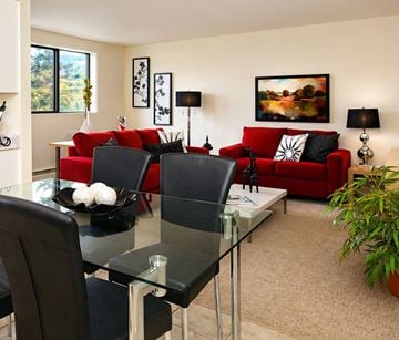 London apartment for rent - A modern living room with a glass dining table and red couch.