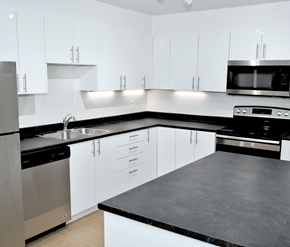 Halifax apartment for rent - A modern kitchen with white cabinets and black countertops.