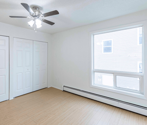 Saint John apartment for rent - A room with a ceiling fan and a window with blinds.