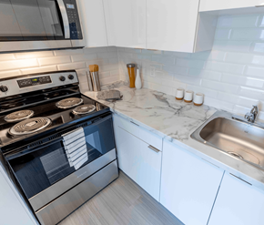 Saint John apartment for rent - A modern kitchen with a stove, sink, and cabinets.
