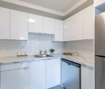 Saint John apartment for rent - A kitchen with white cabinets and a stainless steel refrigerator.