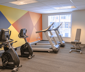 Moncton apartment for rent - A gym with exercise equipment including treadmills and stationary bikes.