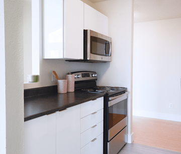 Halifax apartment for rent - A kitchen with white cabinets and black countertops.