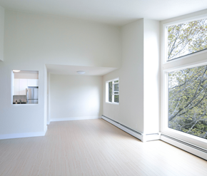 Halifax apartment for rent - A spacious room with a large window overlooking a tree-filled area.