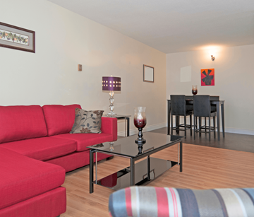 Halifax apartment for rent - A red couch sits in a living room with a glass table in front of it.