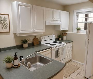 Halifax apartment for rent - A kitchen with white cabinets and a stove top oven.
