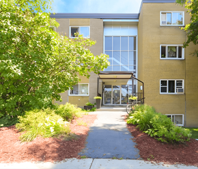 Ottawa apartment for rent - A building with a yellow facade and a glass entrance.