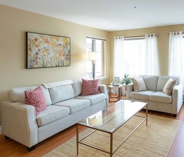 Moncton apartment for rent - A living room with a white couch and a glass coffee table.