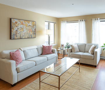 Moncton apartment for rent - A living room with a large painting on the wall and two couches.