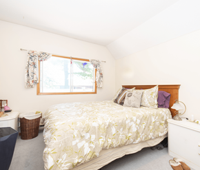 Fredericton apartment for rent - A bedroom with a large bed and a window with curtains.