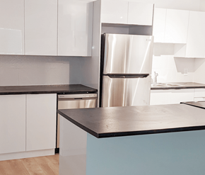 Fredericton apartment for rent - A kitchen with a stainless steel refrigerator and white cabinets.
