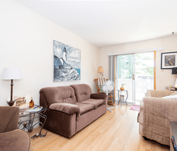 Fredericton apartment for rent - A living room with a brown couch and a painting on the wall.