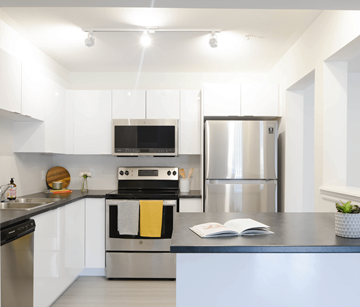 Halifax apartment for rent - A modern kitchen with a stainless steel refrigerator and a black oven.