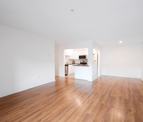 Halifax apartment for rent - A room with wooden floors and a kitchen area in the background.