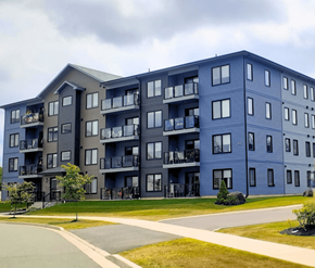 Fredericton apartment for rent - A large apartment building with balconies and multiple windows.