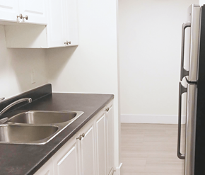 Fredericton apartment for rent - A kitchen with a black countertop and a stainless steel sink.