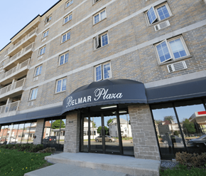 Moncton apartment for rent - The Belmar Plaza building is a multi-story brick structure with a black awning.