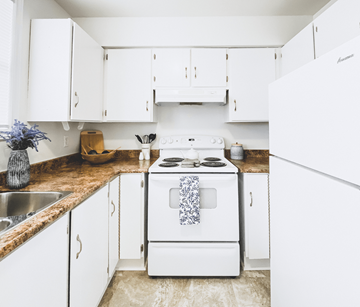 St. John's apartment for rent - A white stove with a blue towel on it is in a kitchen with white cabinets.