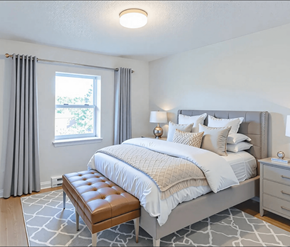 Saint John apartment for rent - A bedroom with a large bed and a bench in front of it.
