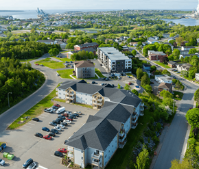 Saint John apartment for rent - A parking lot in front of a building with a large body of water in the background.