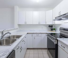 Moncton apartment for rent - A kitchen with white cabinets and a marble countertop.