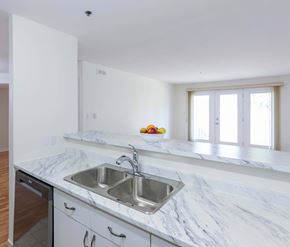 Moncton apartment for rent - A kitchen with a marble countertop and a stainless steel sink.