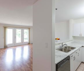 Moncton apartment for rent - A kitchen with white cabinets and a marble countertop.