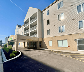 Moncton apartment for rent - A modern building with a parking lot in front.