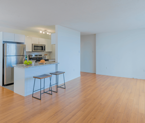 Moncton apartment for rent - A kitchen with a refrigerator, stove, and bar stools.