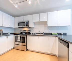 Saint John apartment for rent - A modern kitchen with white cabinets and stainless steel appliances.
