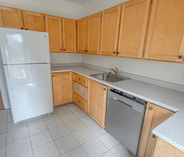 Halifax apartment for rent - A kitchen with a white refrigerator and wooden cabinets.