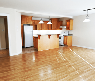 Fredericton apartment for rent - A kitchen with wooden cabinets and a white refrigerator.