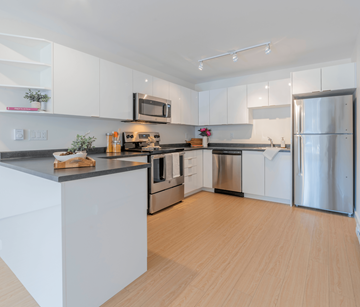 Saint John apartment for rent - A modern kitchen with white cabinets and stainless steel appliances.